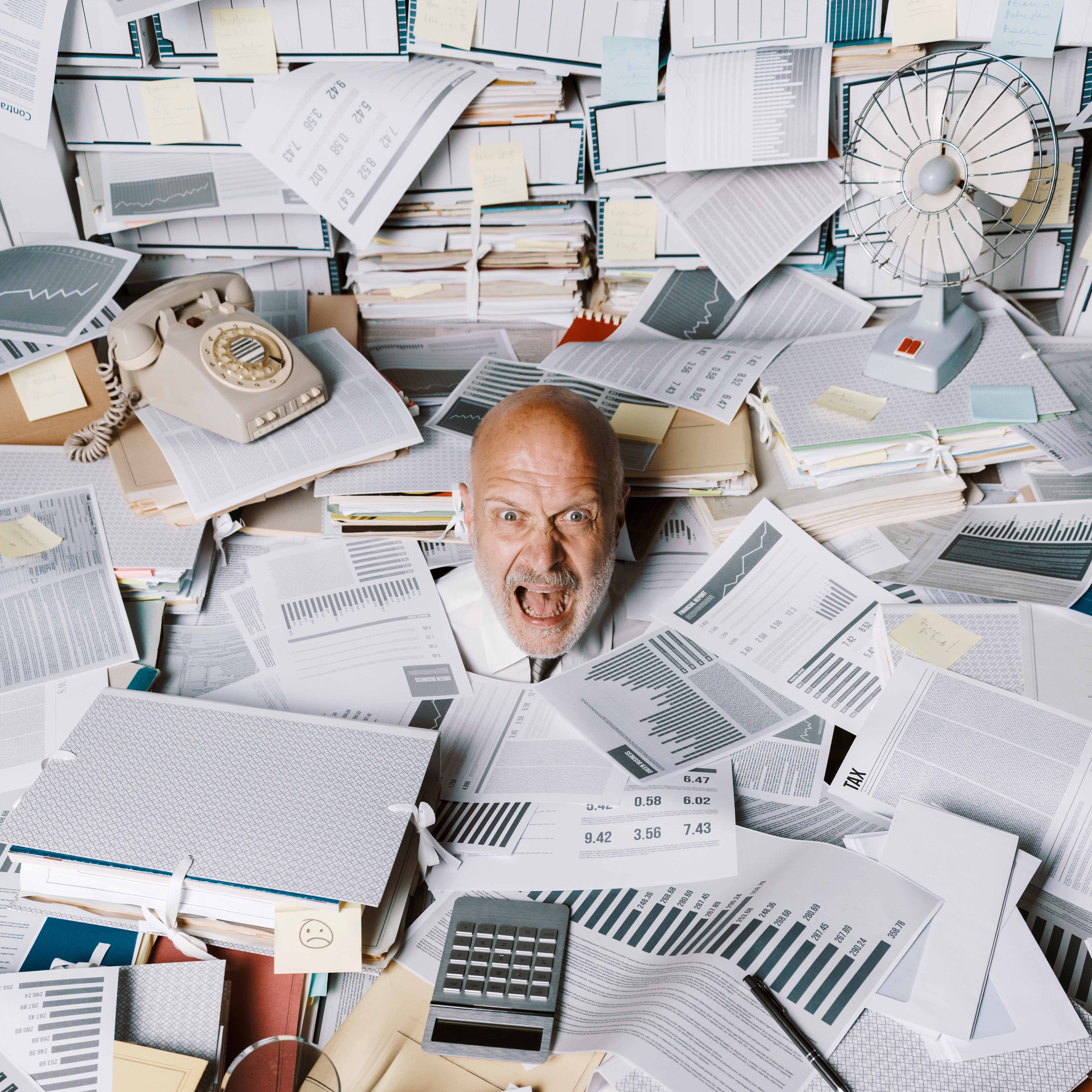 Screaming businessman drowning under a lot of paperwork